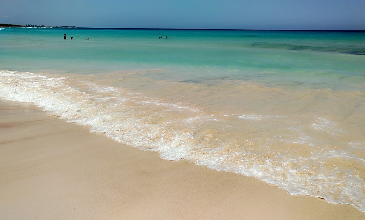 Orilla de Playa Macao: arena dorada, agua transparente y mar turquesa hasta el horizonte.